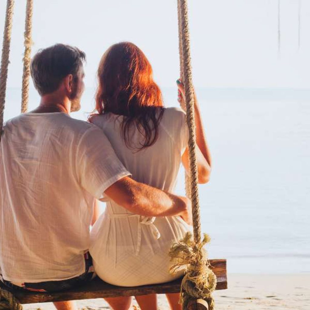 Honeymooners enjoying private candlelit dinner on Mirissa beach at sunset